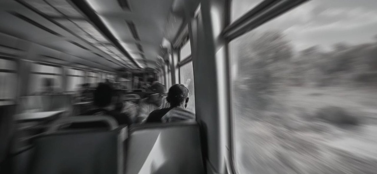 IMAGEM COM UMA PESSOA SENTADA NO METRO E COM VARIAS CADEIRAS