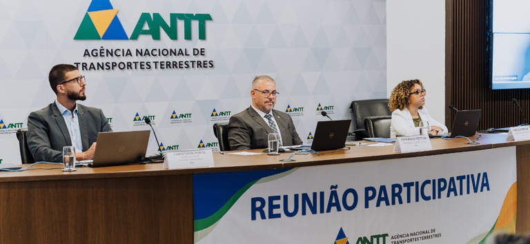 IMAGEM COM TRES PESSOAS SENTADAS NO PALCO
